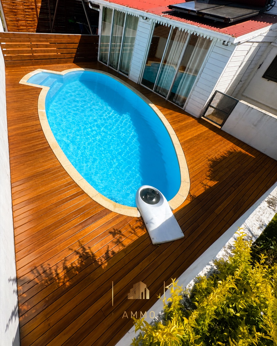 Piscine et plage bois autour d'une maison créole